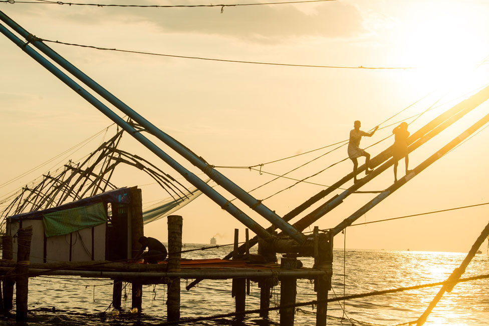 locals fishing using chinese fishing net